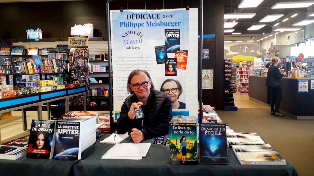 Philippe Meisburger et tous ses romans à sa table de dédicace à l'Espace Culturel Leclerc d'Erstein, devant la très belle affiche annonçant l'événement, le 25 avril 2026.