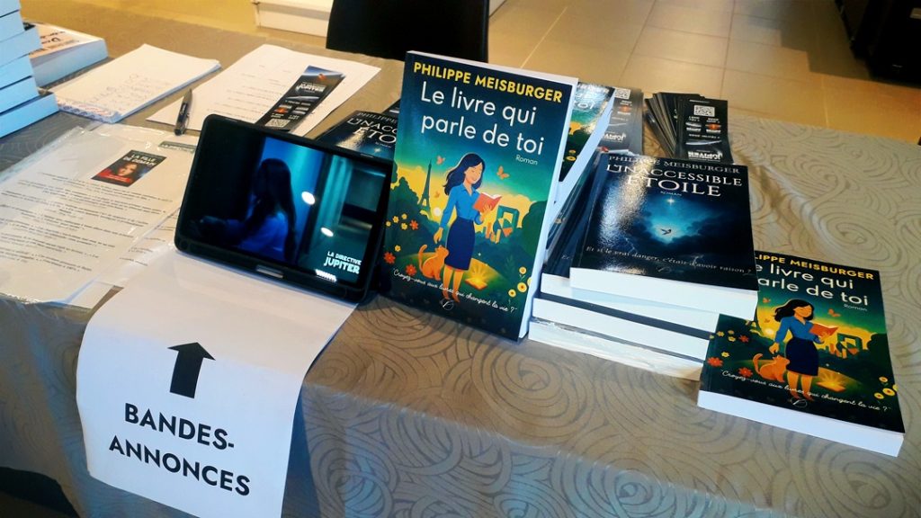 Les romans et la tablette diffusant les booktrailers à l'Espace Culturel Leclerc de Lure, 13 juin 2026